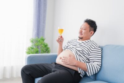 骨盤を後傾させて椅子に座る人